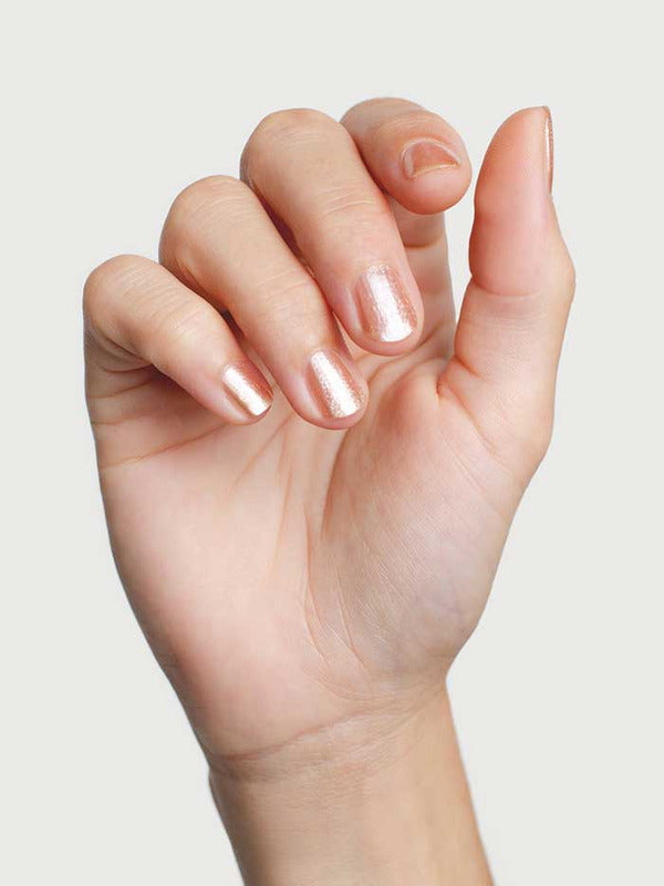 Close-up of a hand wearing Sienna Byron Bay Believe nail polish in a pale shimmering neutral shade.