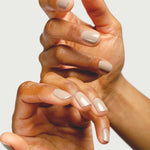 Close-up of hands wearing Sienna Byron Bay Calm nail polish in a soft creamy neutral shade.