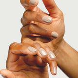 Close-up of hands wearing Sienna Byron Bay Calm nail polish in a soft creamy neutral shade.