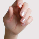Close-up of a hand wearing Sienna Byron Bay Glimmer nail polish, showing the luminous pearl manicure shade.