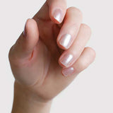 Close-up of a hand wearing Sienna Byron Bay Glimmer nail polish, showing the luminous pearl manicure shade.