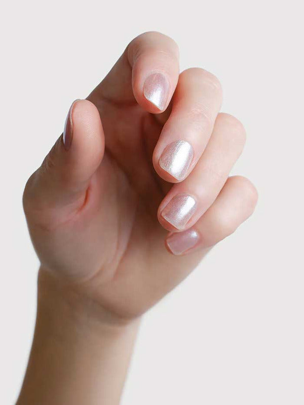Close-up of a hand wearing Sienna Byron Bay Glimmer nail polish, showing the luminous pearl manicure shade.