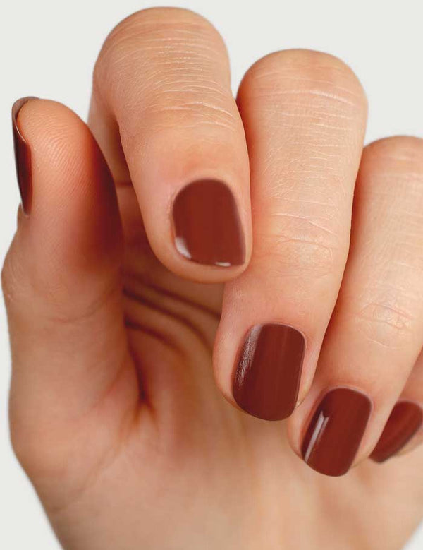 Close-up of natural nails wearing Sienna Byron Bay Sienna nail polish in a warm earthy brown shade.