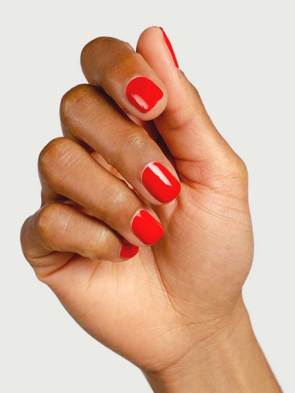 Hand modelling Sienna Byron Bay Passion nail polish, a vivid warm red shade with a high-gloss finish.