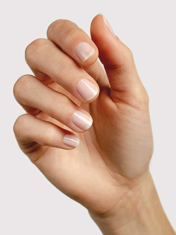 Hand modelling Sienna Byron Bay Peace nail polish, a soft sheer nude-pink shade with a glossy finish.