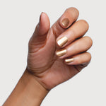 Sienna Divine gold nail polish shown on medium skin tone