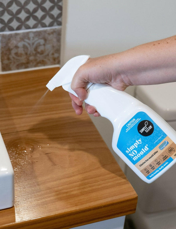 Hand spraying Simply Clean Simply NO Mould in a bathroom