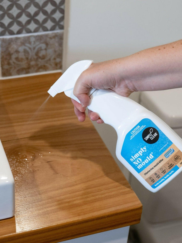 Hand spraying Simply Clean Simply NO Mould in a bathroom