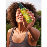 Woman holding Weleda Skin Food Ultra-Light Dry Oil outdoors