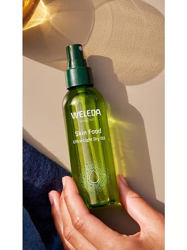 Weleda Skin Food Ultra-Light Dry Oil held in warm sunlight