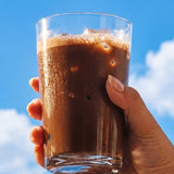 Sodii Everyday Hydration Salts Salty Chocolate iced chocolate held against a blue sky
