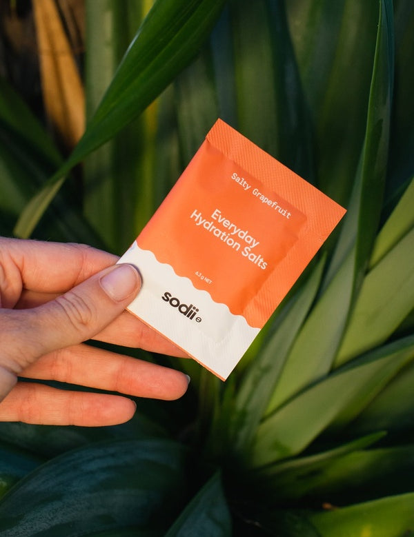 Sodii Everyday Hydration Salts Salty Grapefruit held against tropical greenery