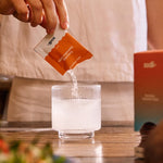 Sodii Everyday Hydration Salts Salty Grapefruit being poured into a glass with a meal