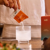 Sodii Everyday Hydration Salts Salty Grapefruit being poured into a glass with a meal