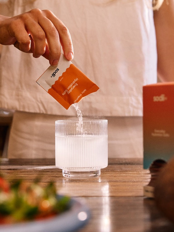 Sodii Everyday Hydration Salts Salty Grapefruit being poured into a glass with a meal