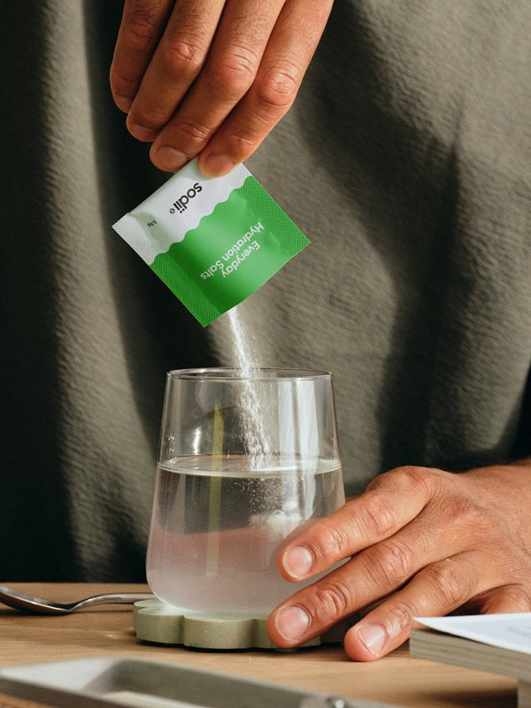Sodii Everyday Hydration Salts Salty Kiwi being poured into a drinking glass