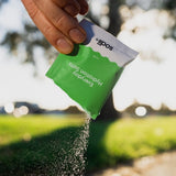 Sodii Everyday Hydration Salts Salty Kiwi being poured into a bottle outdoors