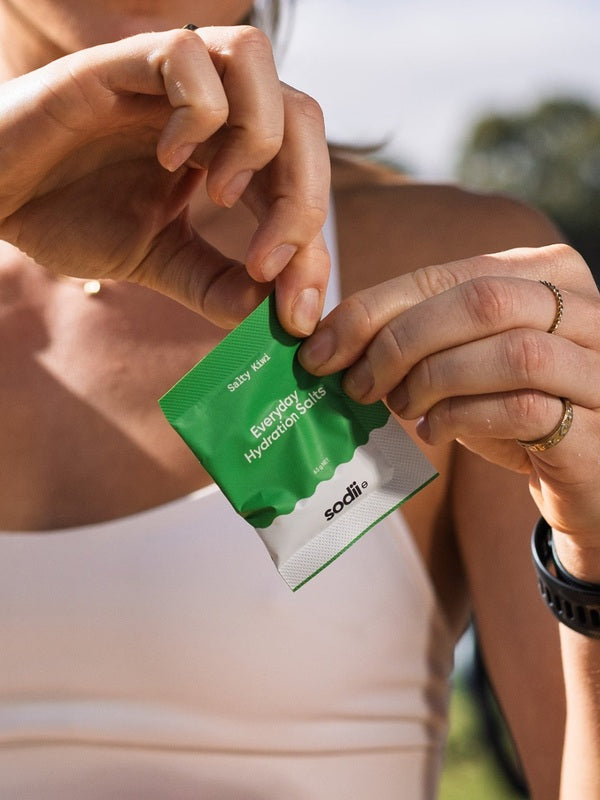 Sodii Everyday Hydration Salts Salty Kiwi sachet being opened outdoors