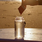 Sodii Everyday Hydration Salts Salty Mandarin being mixed into a bottle at sunset
