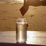 Sodii Everyday Hydration Salts Salty Mandarin being mixed into a bottle at sunset