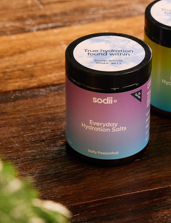 Sodii Everyday Hydration Salts Salty Passionfruit tubs styled on a timber table