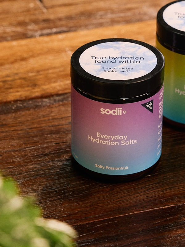 Sodii Everyday Hydration Salts Salty Passionfruit tubs styled on a timber table