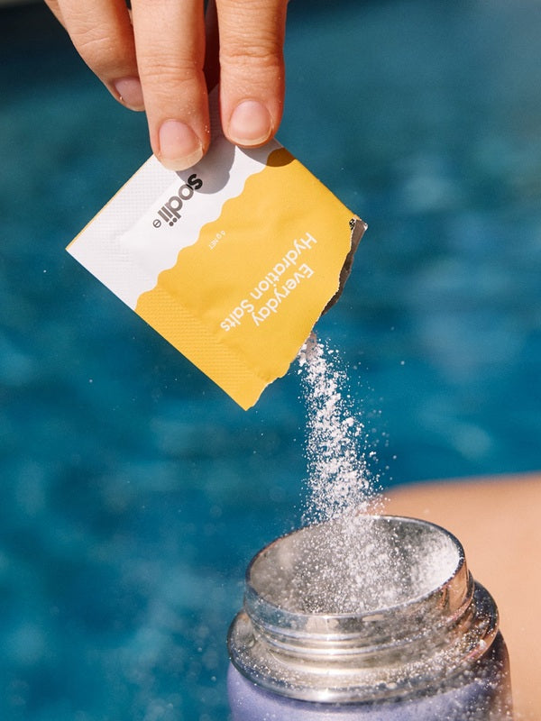 Sodii Everyday Hydration Salts Salty Pineapple being poured into a sports bottle