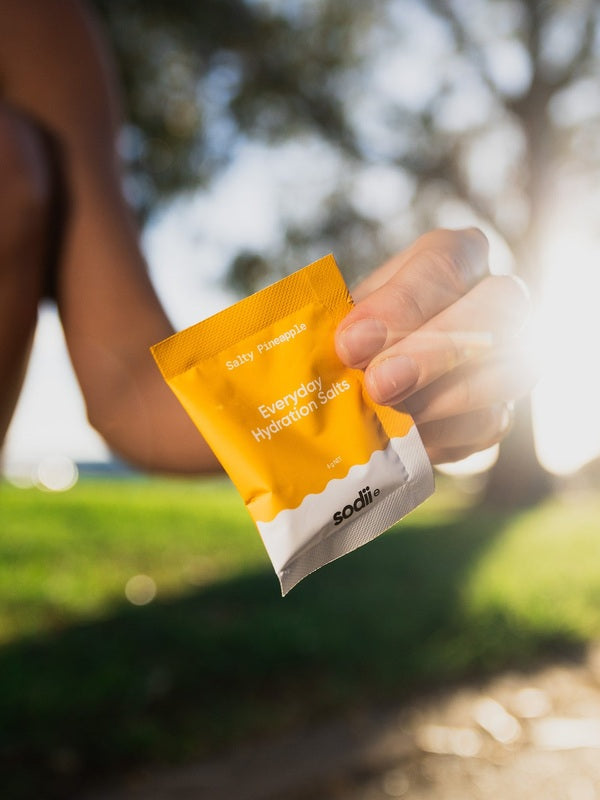 Sodii Everyday Hydration Salts Salty Pineapple held outdoors after exercise