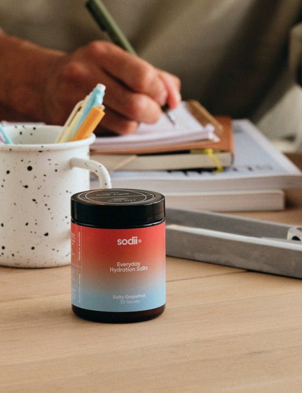 Sodii Everyday Hydration Salts Salty Grapefruit tub in a desk setting