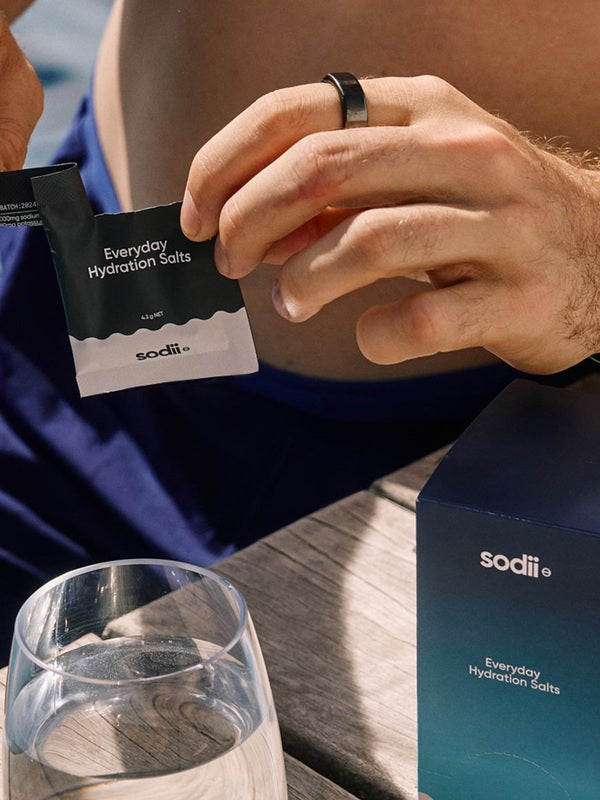 Sodii Everyday Hydration Salts Unflavoured being opened at a cafe table
