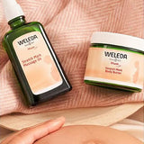 Weleda Stretch Mark Massage Oil and Body Butter beside a pregnant belly.