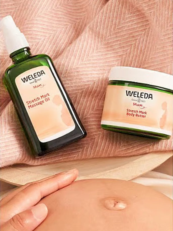 Weleda Stretch Mark Massage Oil and Body Butter beside a pregnant belly.