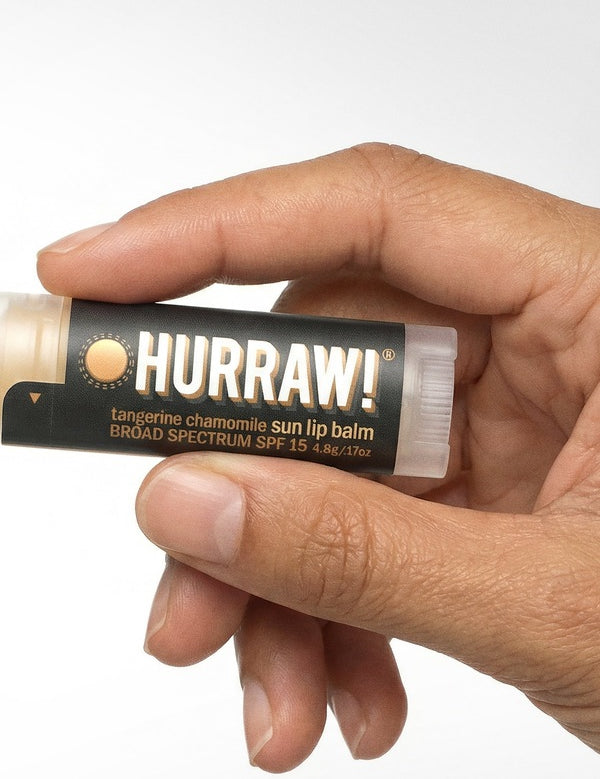 Hand holding Hurraw! Sun Lip Balm SPF15 4.8g