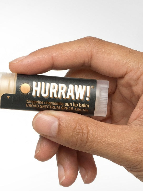 Hand holding Hurraw! Sun Lip Balm SPF15 4.8g