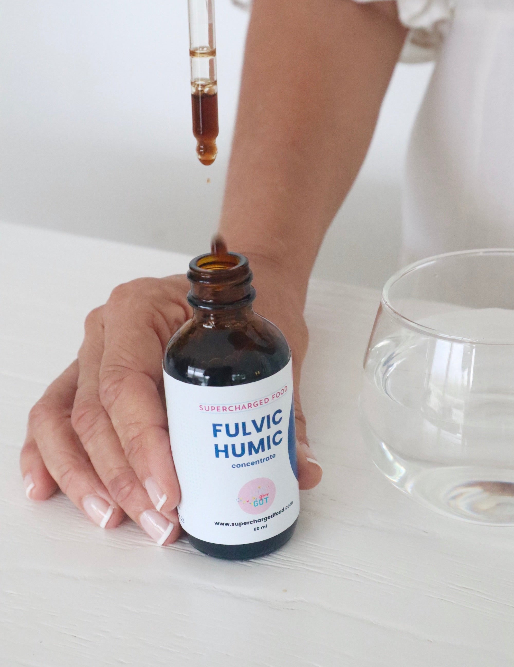Fulvic Humic Concentrate dropper being used beside a glass of water