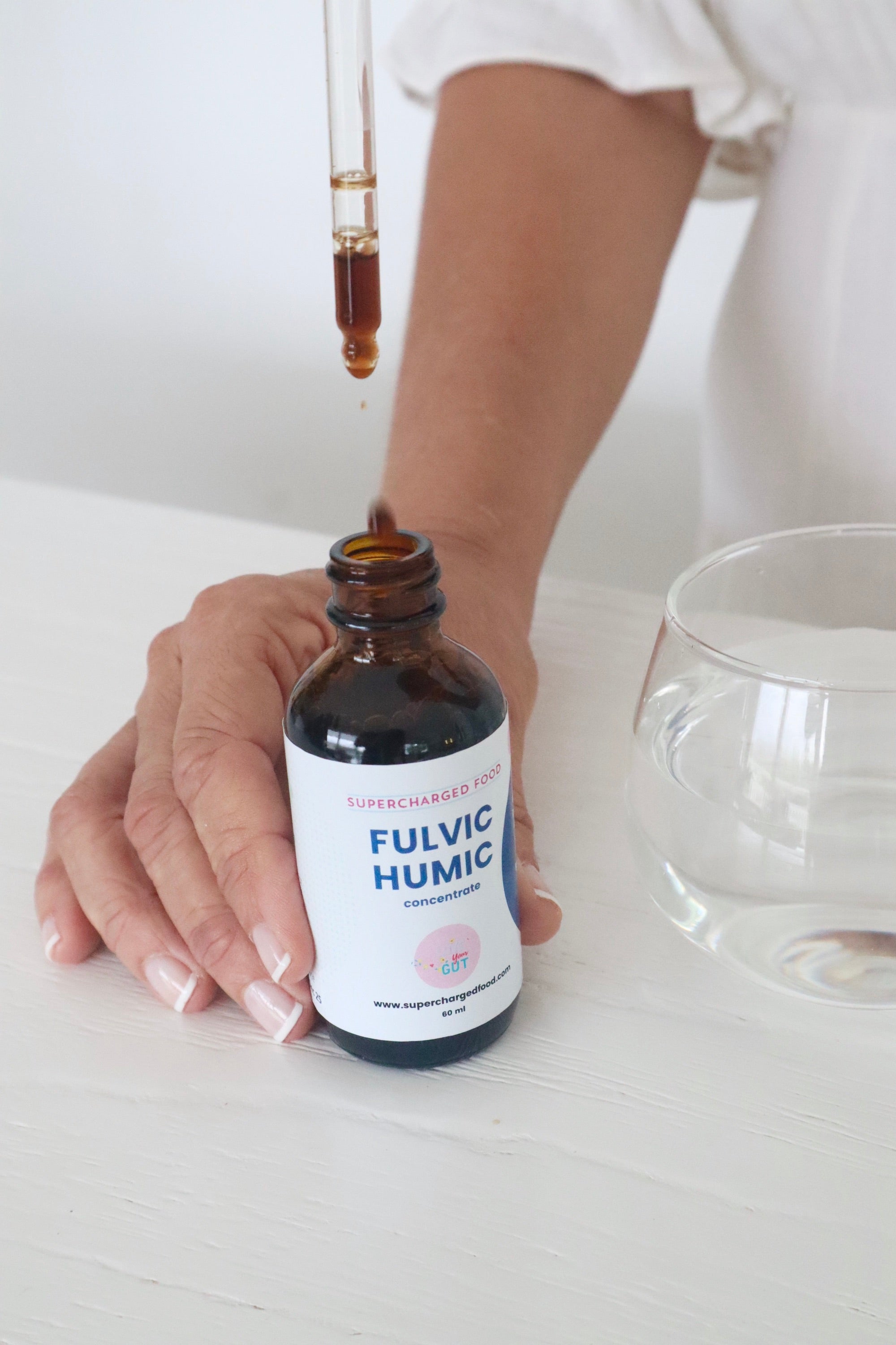 Fulvic Humic Concentrate dropper being used beside a glass of water