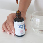 Fulvic Humic Concentrate dropper being used beside a glass of water