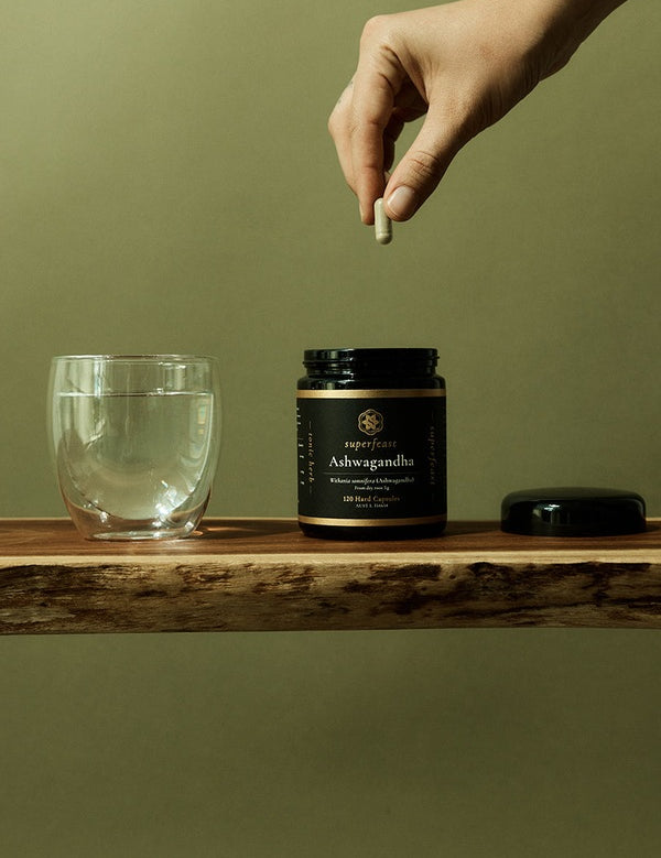 Ashwagandha capsules beside water in a daily wellness ritual