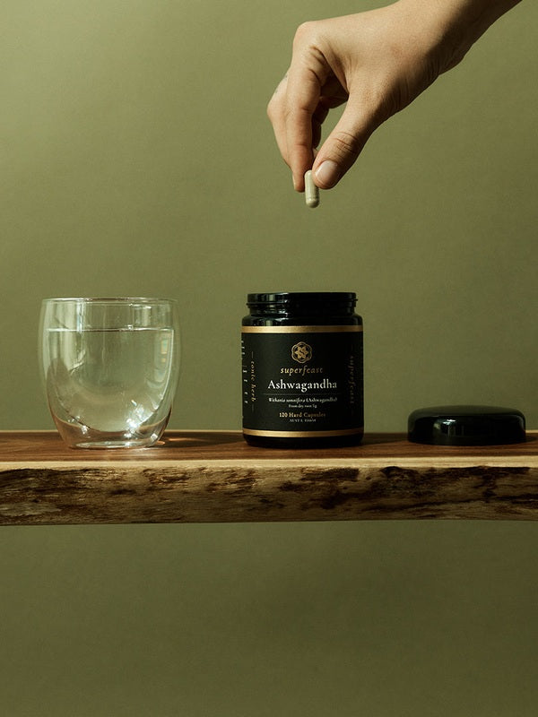 Ashwagandha capsules beside water in a daily wellness ritual