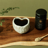 SuperFeast JING beside a prepared tonic in a daily ritual