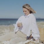 Woman enjoying a Reishi tonic by the sea