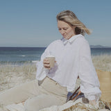Woman enjoying a Reishi tonic by the sea