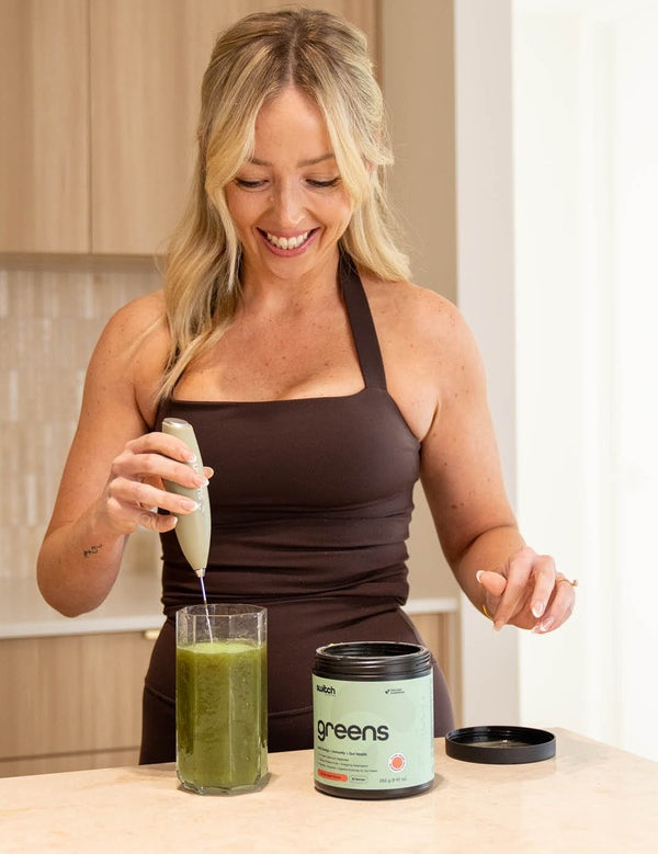 Woman blending a greens drink with Switch Nutrition Sage Green Whiz Stick