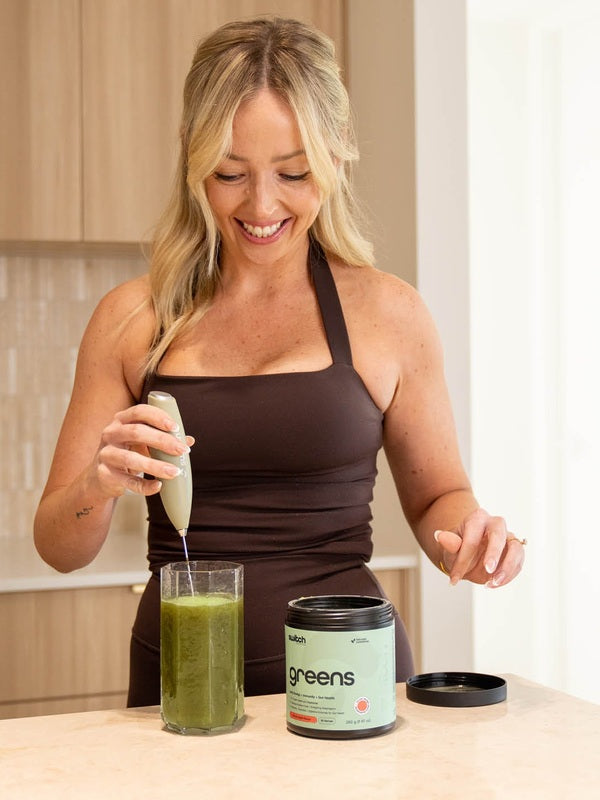 Woman blending a greens drink with Switch Nutrition Sage Green Whiz Stick