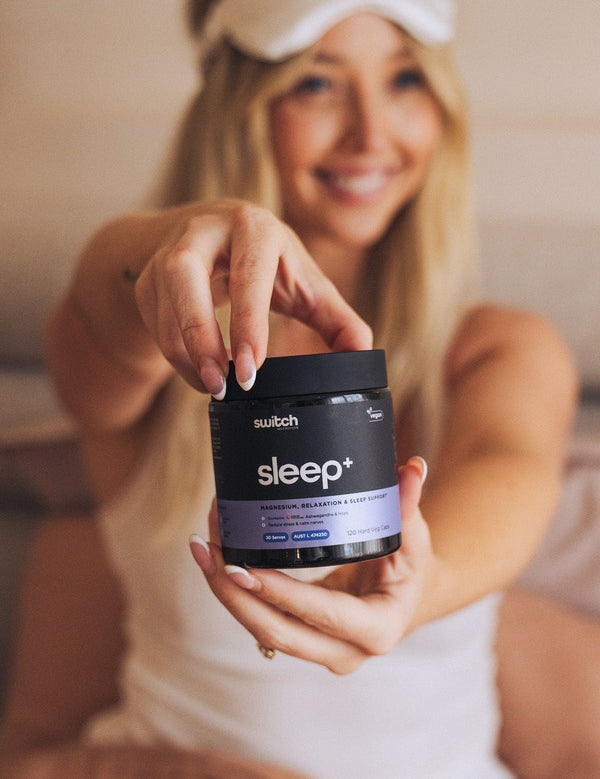 Switch Nutrition Sleep+ Capsules held by a woman in a bedroom