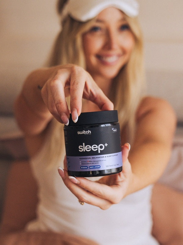 Switch Nutrition Sleep+ Capsules held by a woman in a bedroom