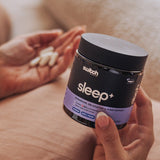 Close-up of Switch Nutrition Sleep+ Capsules jar and capsules in hand