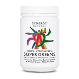 White Synergy Natural Organic Super Greens 500g powder tub with a broad white screw lid and colourful stylised figures above the bold black product name.