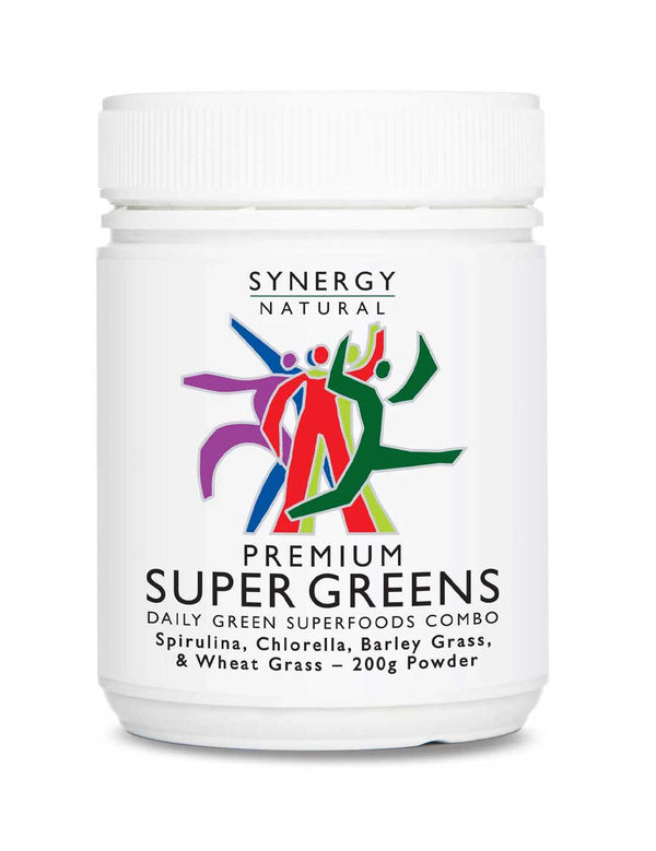 White Synergy Natural Premium Super Greens powder tub with a broad ribbed white lid and colourful stylised figures above large black 'PREMIUM SUPER GREENS' lettering.