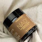 The Age Hack NAD powder styled on soft fabric